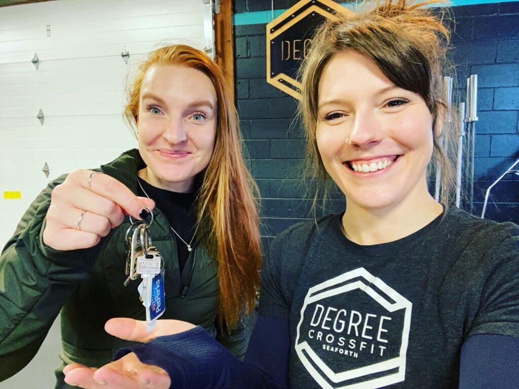 Kaleda passing the keys to one of her coaches who took over the gym